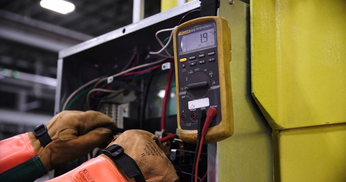 Profissional diagnosticando uma caixa elétrica com instrumento de medição